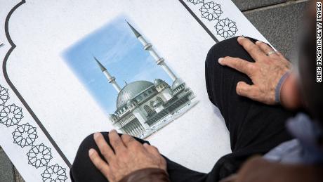 A man participates in Friday prayers outside the Taksim Mosque during the opening ceremony.