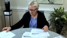 Irena Schulz looks through her medical bills