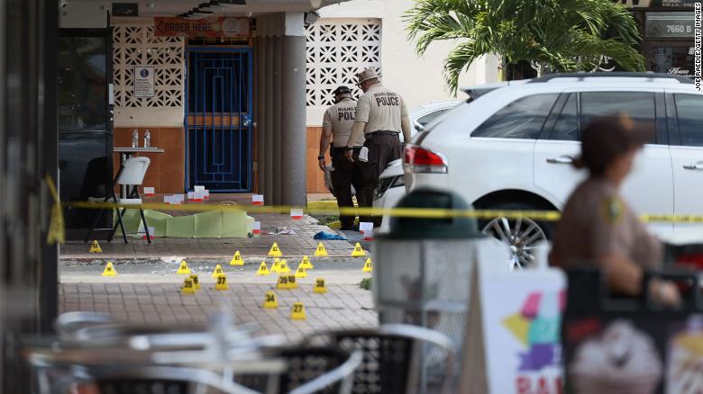 Miami-Dade police investigate Sunday near shell case markers on the ground.