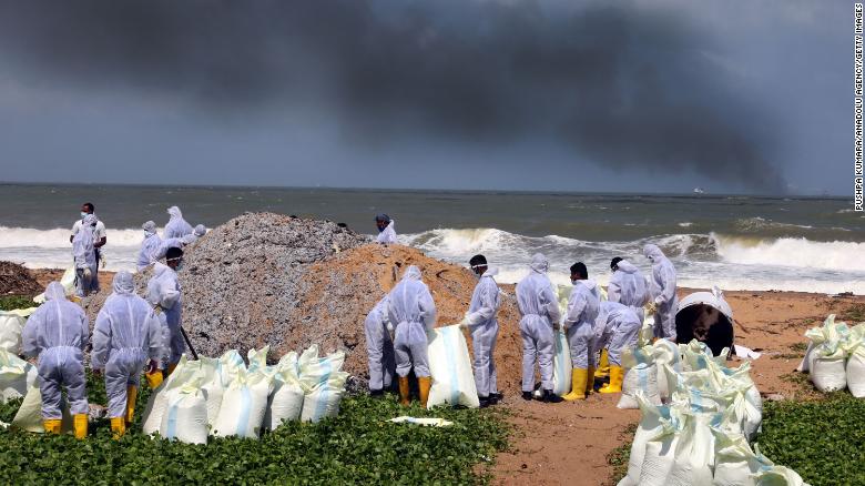 Sri Lanka Navy personnel remove waste washed ashore from the burning cargo vessel MV X-Press Pearl on the beaches of Wattala to Negombo in the suburbs of Colombo, on May 28.