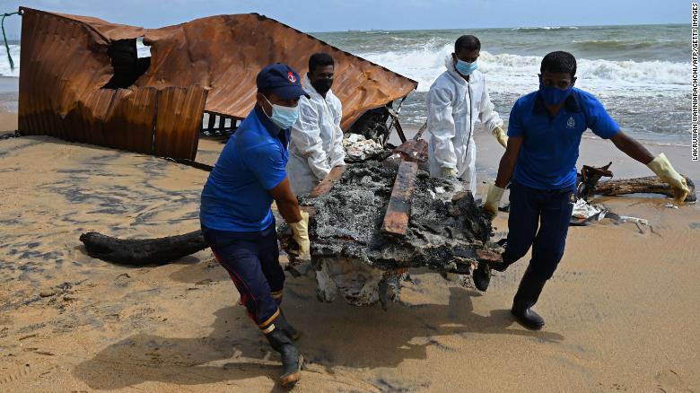 Members of the Sri Lanka Navy remove debris washed ashore from the Singapore-registered container ship MV X-Press Pearl.