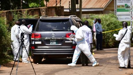 Forensic experts secure the scene outside the home of Ugandan minister of works and transport General Katumba Wamala.