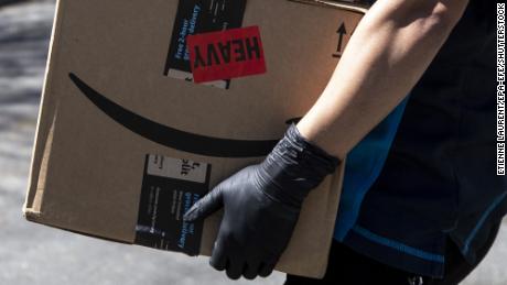 An Amazon delivery woman delivers packages amid the coronavirus pandemic in Los Angeles, California, in March 2020. 