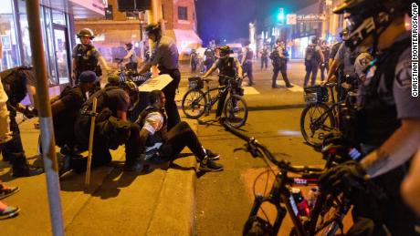 Police arrest protesters in Minneapolis early Saturday morning. 