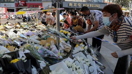 People lay flowers at the site of a stabbing that left 6 pedestrians dead and 14 wounded in the Chinese city of Anqing on June 6, 2021.