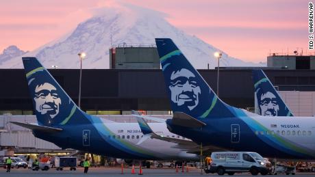 Alaska Airlines planes are shown parked at gates with Mount Rainier in the background at sunrise on Monday, March 1, 2021 at Seattle-Tacoma International Airport in Seattle. 