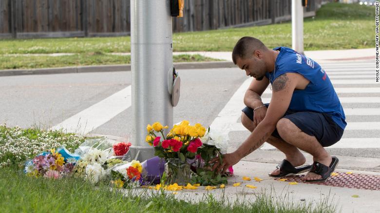 A man places flowers and pays his respects at the scene in London, Ontario, on Monday, June 7. 