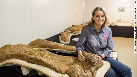 Robyn Mackenzie, mede-oprichter van het Eromanga Natural History Museum, naast een gefossiliseerd dinosaurusskelet.