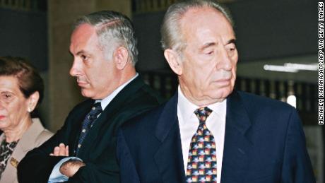 Netanyahu, then the Israeli prime minister-elect, stands next to outgoing premier Shimon Peres in the Knesset in 1996.