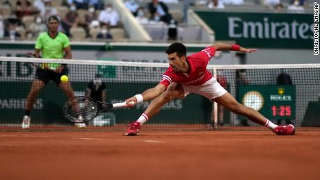 Novak Djokovic stretches to return the ball during his French Open semifinal match against Rafa Nadal.