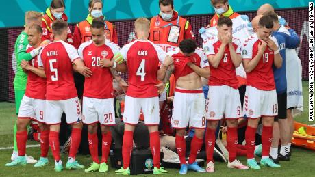 Denmark&#39;s players gather as paramedics attend to midfielder Christian Eriksen (not seen) during Saturday&#39;s match.