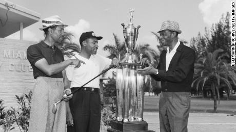 Sifford receives the North South Negro Golf Tournament trophy from Nat nightclub celebrity "King"  Cole. 