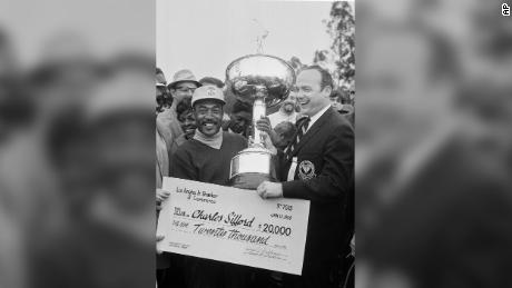 Sifford receives a check for $20,000 plus a trophy after winning the Los Angeles Open.