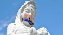 Workers place a mask on a 57-metre-high statue of Buddhist goddess Kannon to pray for the end of the coronavirus disease (COVID-19) pandemic at Houkokuji Aizu Betsuin temple in Aizuwakamatsu, Fukushima Prefecture, Japan in this handout photo taken on June 15 2021. Picture taken on June 15, 2021. Houkokuji Aizu Betsuin/Handout via REUTERS ATTENTION EDITORS - THIS IMAGE HAS BEEN SUPPLIED BY A THIRD PARTY. NO RESALES. NO ARCHIVES. MANDATORY CREDIT