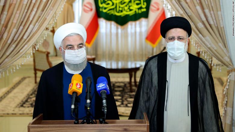 In this photo released by the official website of the office of the Iranian Presidency, President Hassan Rouhani, left, speaks with the media after his meeting with President-elect Ebrahim Raisi, right, who is current judiciary chief, in Tehran, Iran, Saturday, June 19, 2021. 