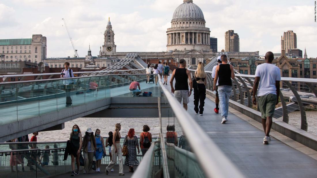Pedestrians, some in masks, cross London's Millennium footbridge. The British government didn't make face coverings compulsory indoors or on public transport until last summer, and masks have never been mandated outdoors.