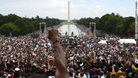 A participant raises his first during the &quot;Commitment March: Get Your Knee Off Our Necks&quot; protest against racism and police brutality on August 28, 2020, at the Lincoln Memorial in Washington, DC. 