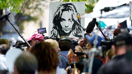 A portrait of Britney Spears looms over supporters and media members outside a court hearing concerning the pop singer&#39;s conservatorship at the Stanley Mosk Courthouse, Wednesday, June 23, 2021, in Los Angeles. (AP Photo/Chris Pizzello)