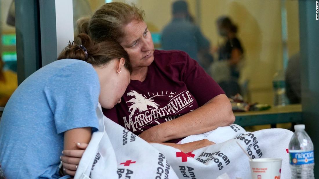 Jennifer Carr sits with her daughter as they and other evacuees wait for news at the family reunification center in Surfside.