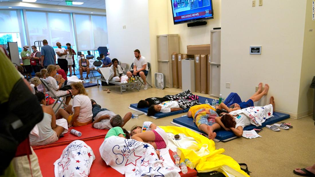 People lie on cots at the family reunification center in Surfside.