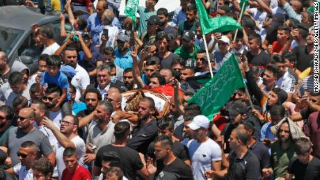 Mourners walk in a funeral procession with the body of human rights activist and critic of the Palestinian Authority Nizar Banat.