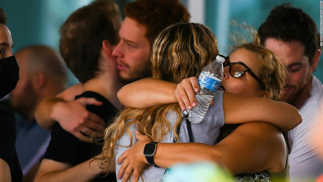 People hug June 25 as they wait for news about their relatives at a community center in Surfside.