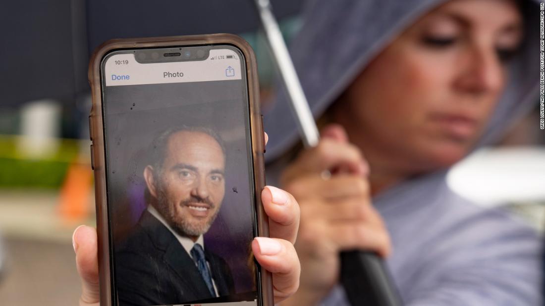 Toby Fried holds up a picture of her missing brother, Chaim Rosenberg, outside the Surfside Community Center on June 25.