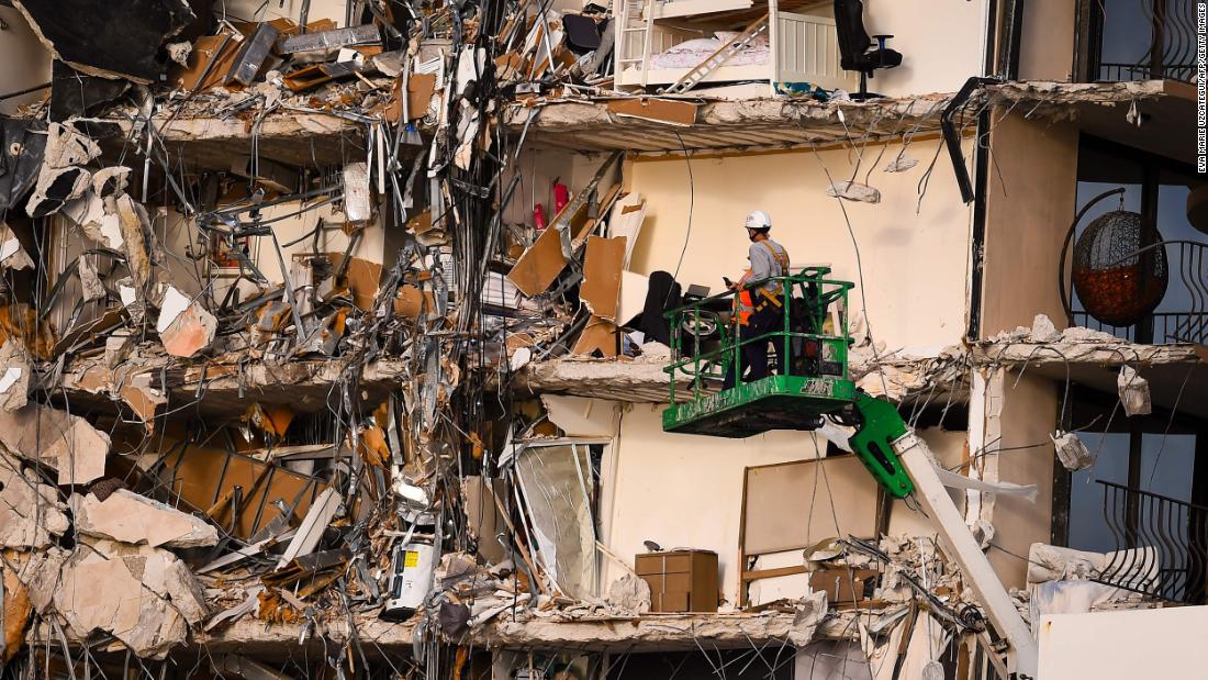 Rescue workers use a crane to inspect the damage.