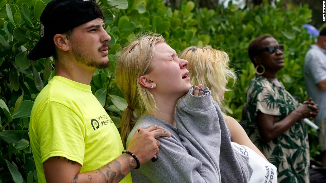 Ariana Hevia, center, stands with Sean Wilt near the partially collapsed building on June 25. Hevia&#39;s mother, Cassandra Statton, lives in the building.