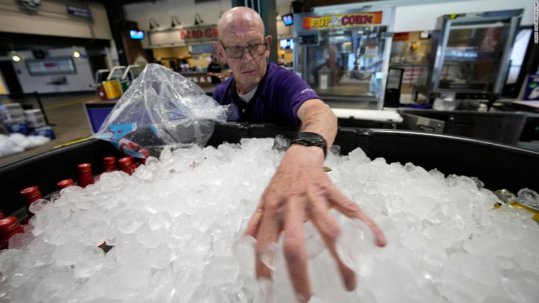 James Oehlerking spreads ice over a tub of bottled beer at Coors Field, the home of Major League Baseball&#39;s Colorado Rockies, on June 17. Temperatures were in the triple digits for a third straight day in Denver.