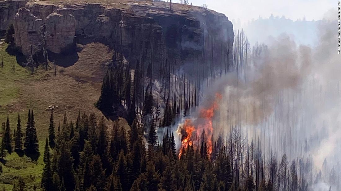 A wildfire burns on a canyon wall south of St. Xavier, Montana, on June 15. Record-high temperatures and gusting winds stoked a rapid expansion of major fires across central and eastern Montana.