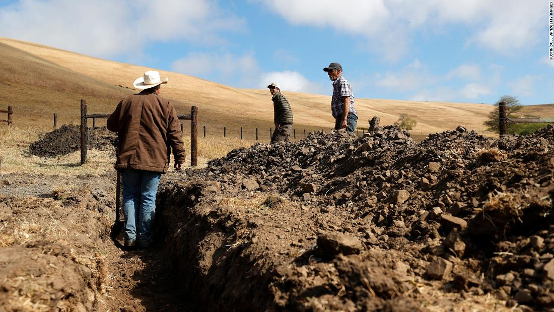 Ranchers Jim Jensen, center, and Bill Jensen inspect a trench they are working on to try to get more water to their ranch in Tomales, California, on June 8. As the drought continues in California, many ranchers and farmers are beginning to see their wells and ponds dry up. They are having to make modifications to their existing water resources or have water trucked in for their livestock.