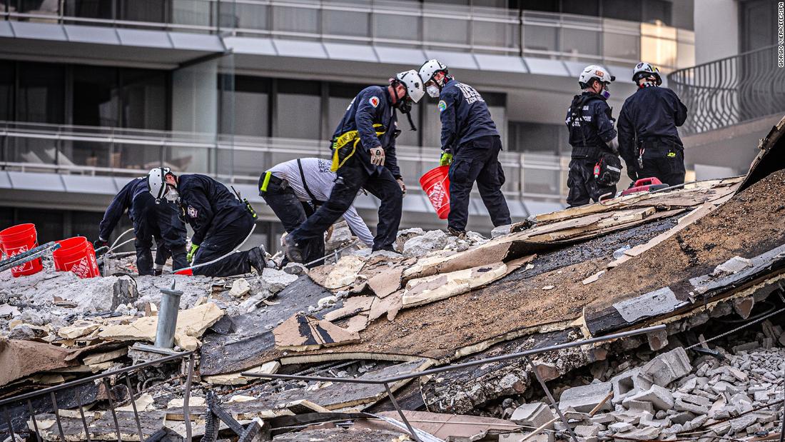 Members of a search-and-rescue team work in the rubble.