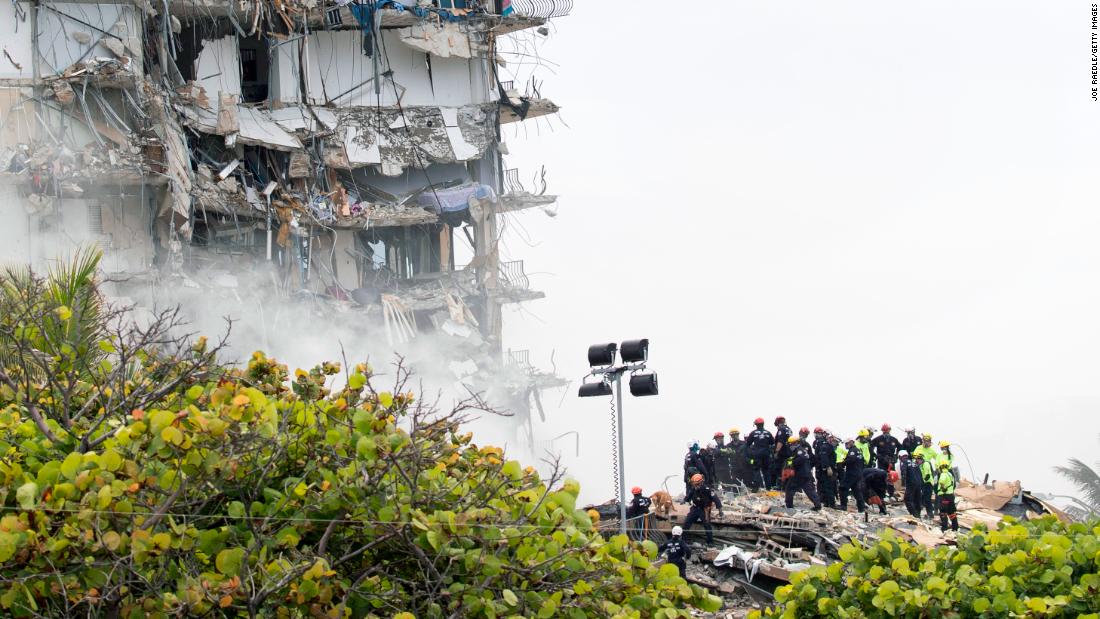 Rescue personnel search through the building&#39;s rubble on June 25.