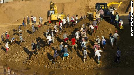 Freelance miners digging for raw jade stones in piles of waste rubble dumped by mechanical diggers, next to a jade mine in Hpakant on October 4, 2015.