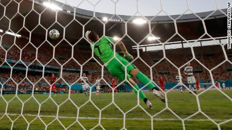 Portugal&#39;s goalkeeper Patricio fails to save the shot by Hazard.