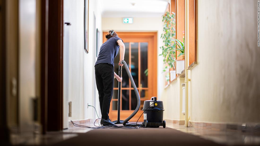 A woman vacuums a hallway in a hotel on May 31, 2021, in Hamburg. Since June 1, hotels in Hamburg have been allowed to receive guests again at 60% capacity. 