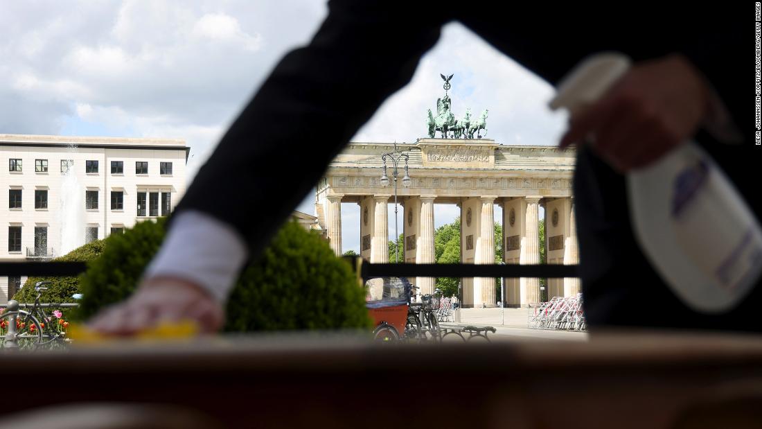 A waiter cleans a restaurant table ahead of reopening in Berlin, Germany, on May 21, 2021. 