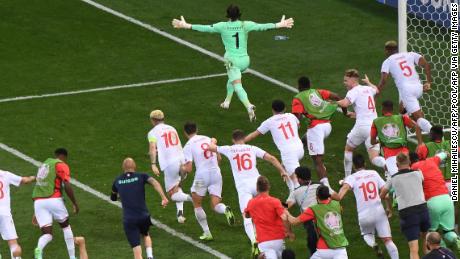 Switzerland goalkeeper Yann Sommer wheels away in celebration after saving Kylian Mbappe&#39;s penalty.