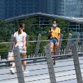 People walk along a pedestrian bridge at the financial business district in Singapore on June 25, 2021. (Photo by Roslan RAHMAN / AFP) (Photo by ROSLAN RAHMAN/AFP via Getty Images)