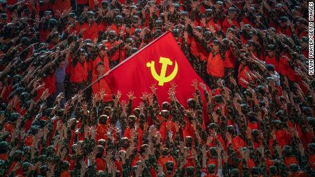 Performers surround a large Communist Party flag during a mass gala marking the 100th anniversary of the Communist Party on June 28, 2021 at the Olympic Bird&#39;s Nest stadium in Beijing.