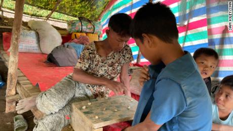 Refugee children from villages in Chin State emptied for fear of an attack by the Myanmar army spend their time playing artisan checkers.
