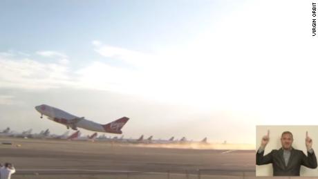 Virgin Orbit&#39;s retrofitted Boeing 747 airplane, with a rocket affixed beneath the wing, takes off from California ahead of launch.