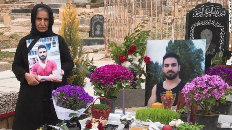 Navid&#39;s mother (left) stands by Navid&#39;s grave in March 2021 in Shiraz, Iran.