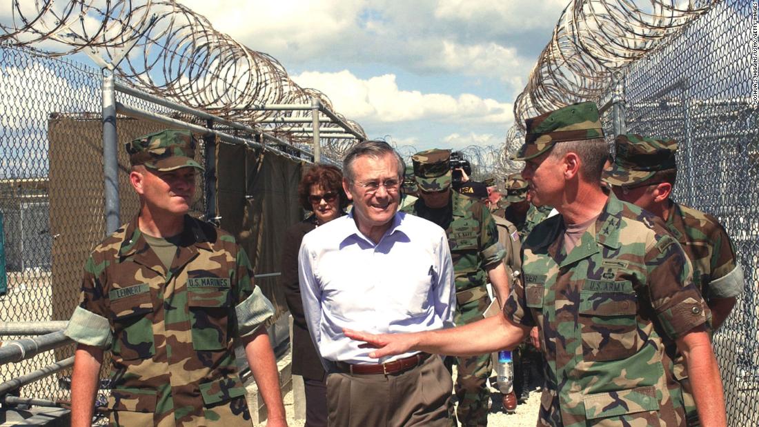 Rumsfeld tours the detention facility Camp X-Ray while visiting Guantanamo Bay, Cuba, in 2002. Rumsfeld said that the Taliban and al Qaeda prisoners being held at the base would not be given prisoner-of-war status.