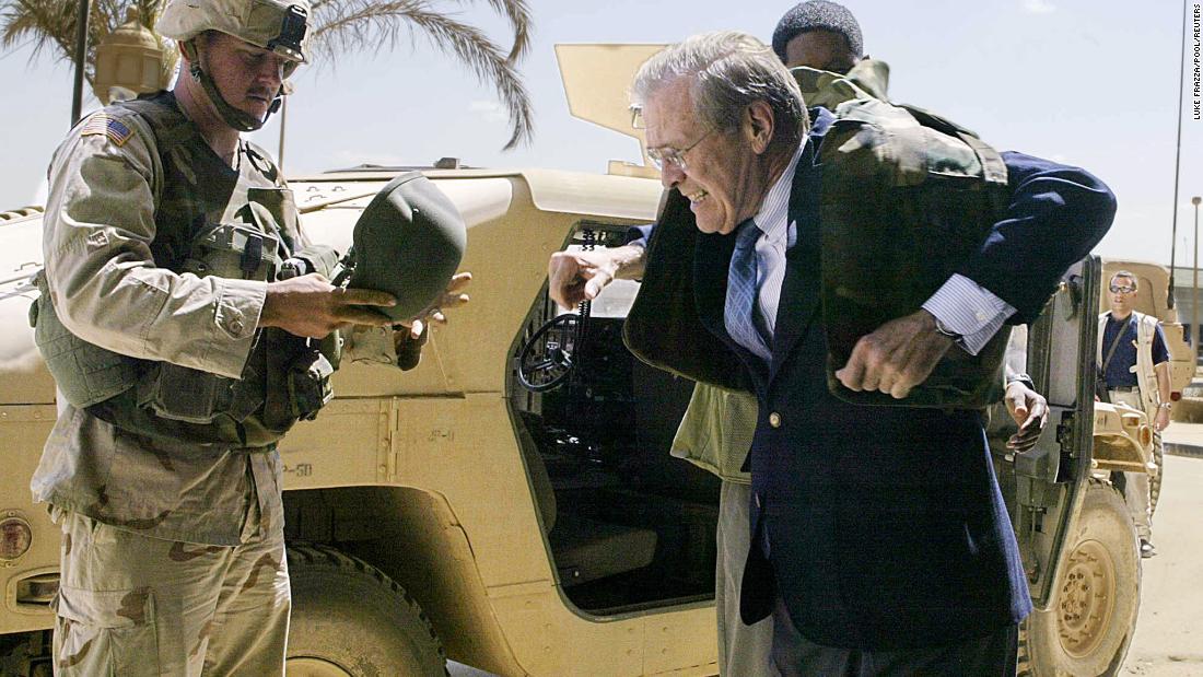 Rumsfeld puts on a bulletproof jacket while visiting Baghdad, Iraq, in April 2003.