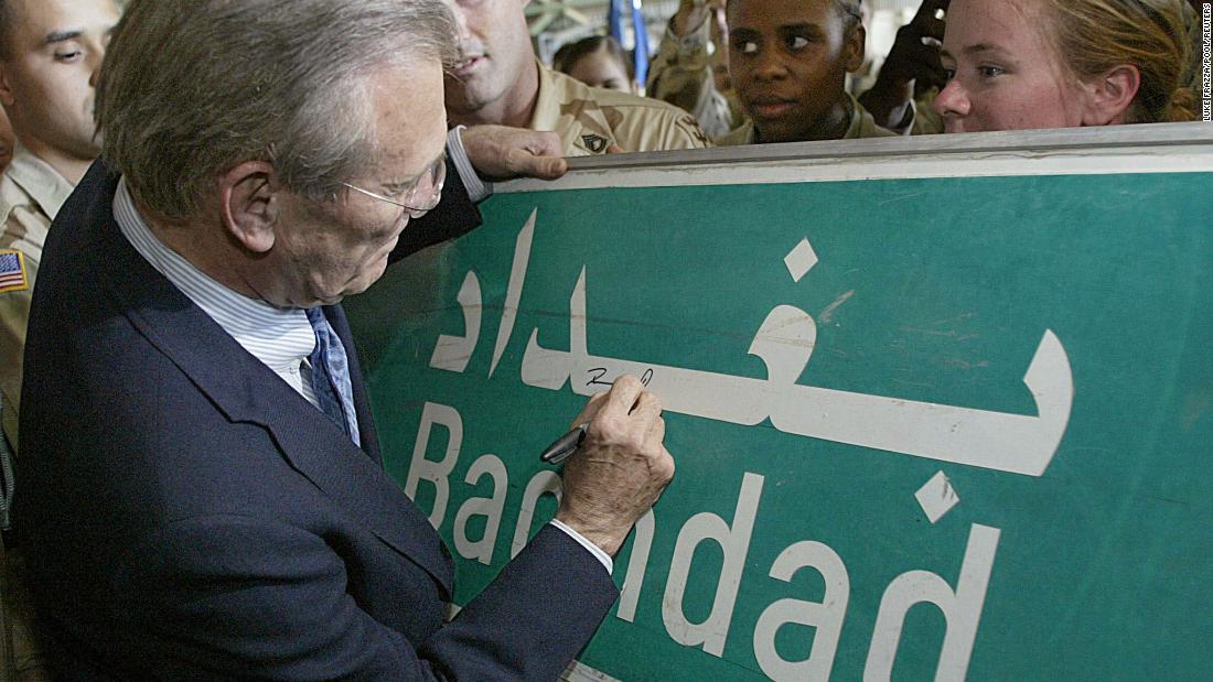 Rumsfeld signs a Baghdad road sign at the request of a US soldier in April 2003.