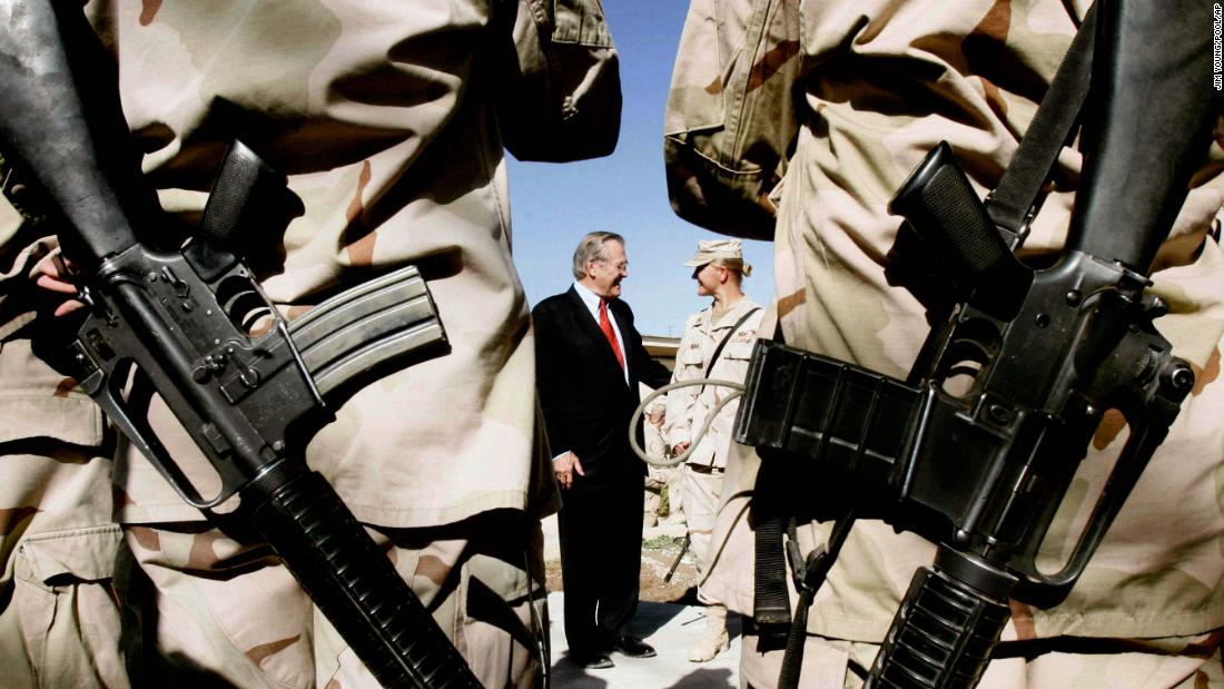 US soldiers from the 173rd Airborne Brigade wait to have their picture taken with Rumsfeld in Kandahar, Afghanistan, in December 2005.