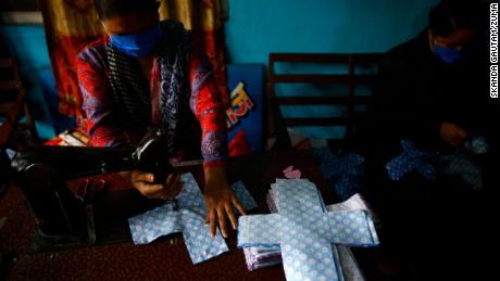 Un volontaire coud du tissu pour fabriquer des serviettes hygiéniques réutilisables à Sinamangal à Katmandou, au Népal.