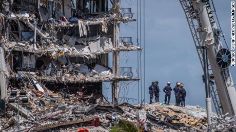 TOPSHOT - Members of the South Florida Urban Search and Rescue team look for possible survivors in the partially collapsed 12-story Champlain Towers South condo building on June 27, 2021 in Surfside, Florida. - The death toll after the collapse of a Florida apartment tower has risen to nine, the local mayor said on June 27, 2021, more than three days after the building pancaked as residents slept. &quot;We were able to recover four additional bodies in the rubble... So I am confirming today that the death toll is at nine,&quot; Miami-Dade County mayor Daniella Levine Cava told reporters in Surfside, near Miami Beach, adding that one victim had died in hospital. &quot;We&#39;ve identified four of the victims and notified next of kin.&quot; (Photo by Giorgio Viera / AFP) (Photo by GIORGIO VIERA/AFP via Getty Images)